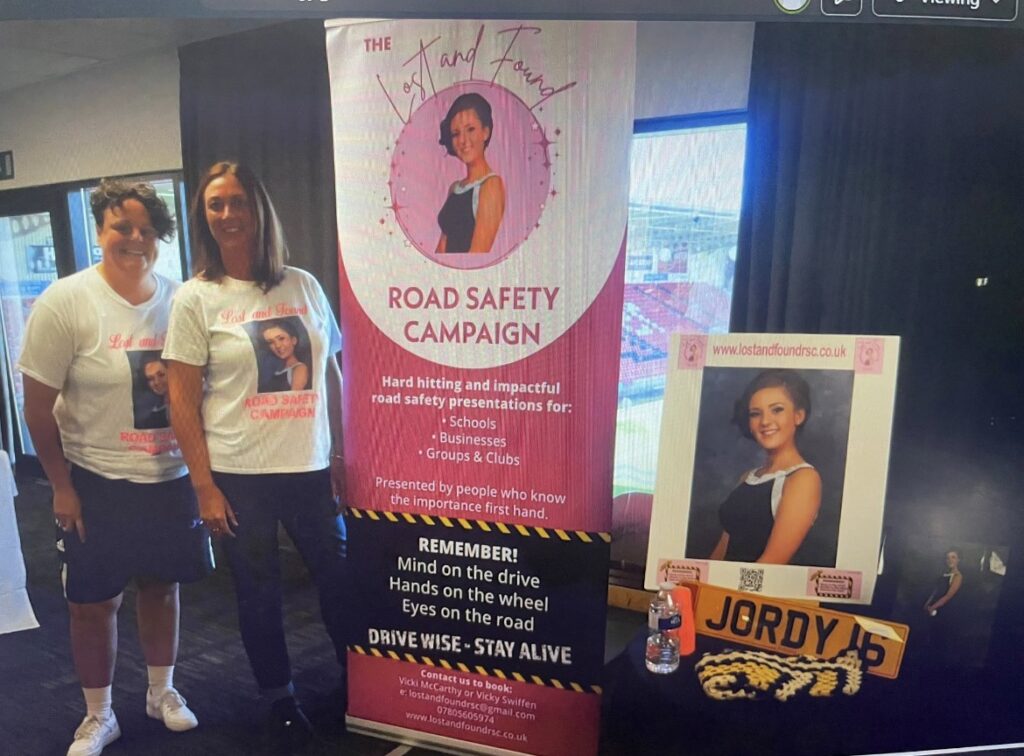 Vicki and Vicky beside the Lost and Found Road Safety Campaign banner and Jordy's photo at the Volker staff presentation